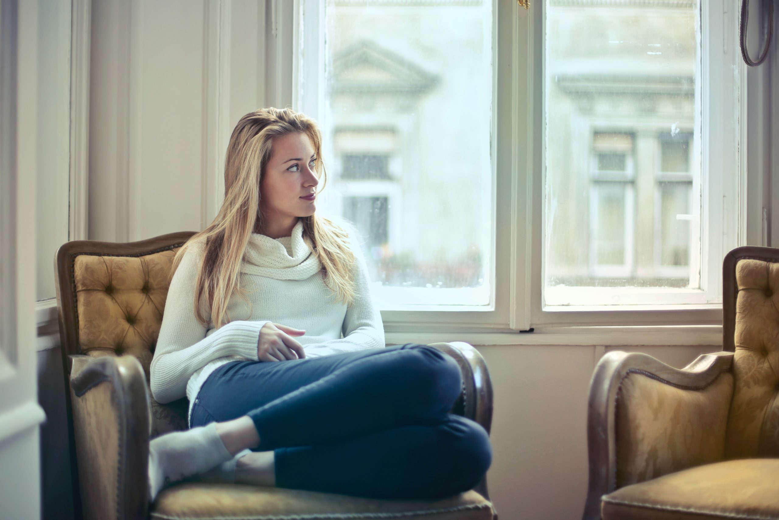 Photograph of woman sitting on a chair near a window